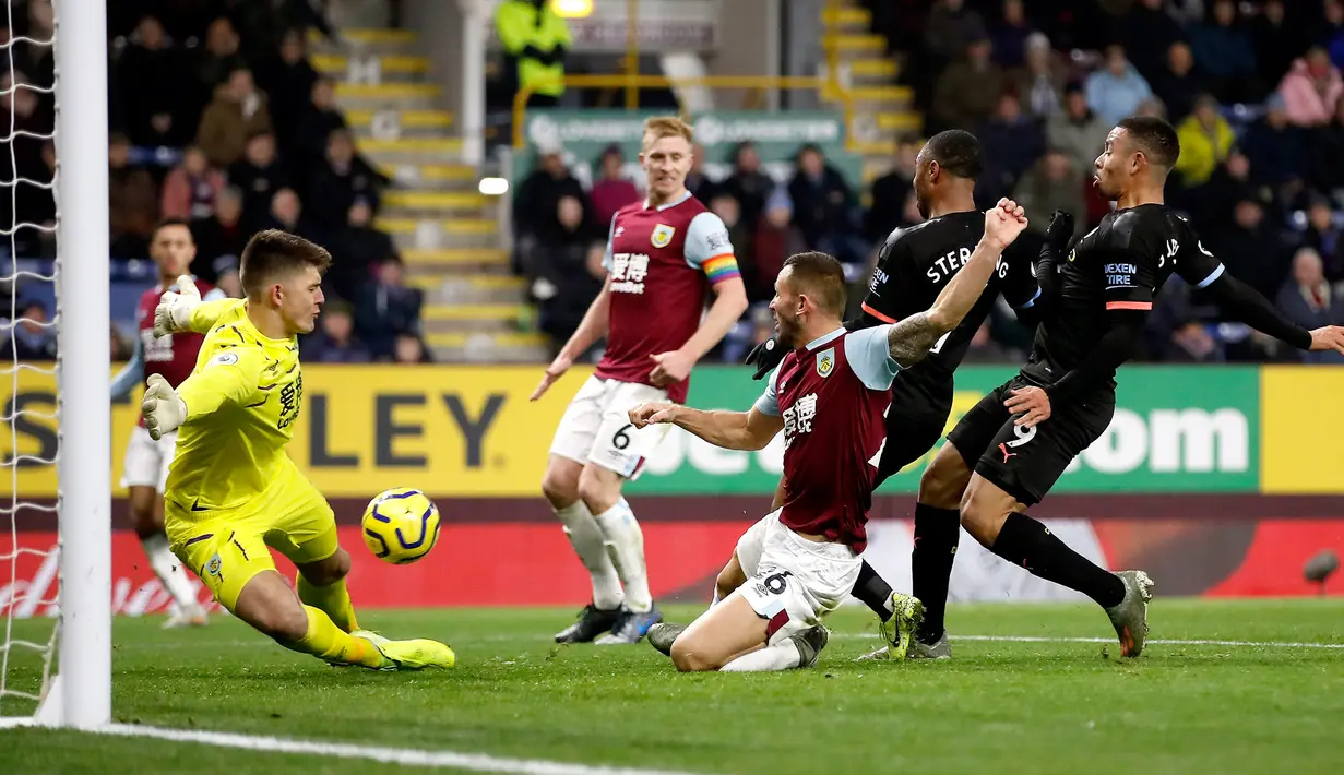 Kiper Burnley Nick Pope (kiri) menepis tendangan dari pemain Manchester City Gabriel Jesus (kanan) pada pertandingan Liga Inggris di Turf Moor, Burnley, Inggris, Selasa (3/12/2019). The Citizens mencukur Burnley 1-4, Gabriel Jesus mencetak dua gol. (Martin Rickett/PA via AP)