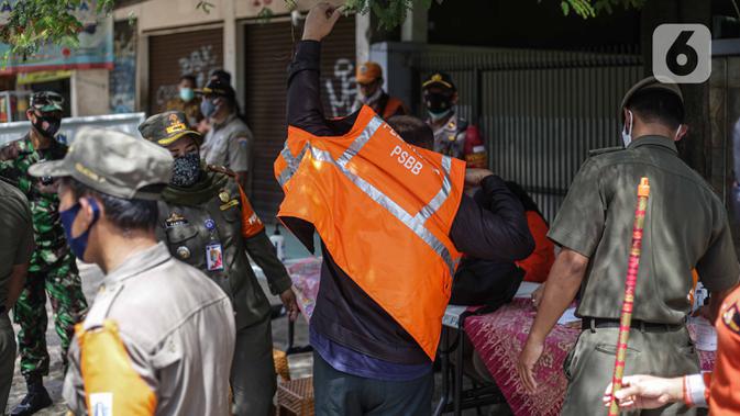 Petugas saat razia masker di kawasan Karang Tengah Lebak Bulus, Jakarta, Selasa (24/11/2020). Denda tersebut terkumpul sejak penerapan Peraturan Gubernur Nomor 51 tahun 2020 pada Juni 2020 lalu. (Liputan6.com/Faizal Fanani)