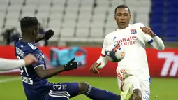 Striker Bordeaux, Amadou Traore (kiri) berebut bola dengan bek Lyon, Marcelo dalam laga lanjutan Liga Prancis 2020/21 pekan ke-22 di Groupama Stadium, Jumat (29/1/2021). Bordeaux kalah 1-2 dari Lyon. (AP/Laurent Cipriani)