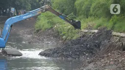 Sebuah alat berat mengeruk lumpur excavator mengeruk material endapan lumpur di kanal sungai perkantoran Kuningan Jakarta, Rabu (17/2/2021). Pengerukan dilakukan untuk memperlancar aliran air agar tidak terjadi pendangkalan yang mengakibatkan genangan air. (merdeka.com/Imam Buhori)