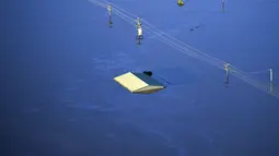 Atap bangunan terlihat terendam air banjir yang menutupi area yang luas di barat laut Sydney, Australia, Rabu  (24/3/2021).  Sekitar 18.000 penduduk negara bagian terpadat di Australia telah meninggalkan rumah mereka sejak pekan lalu, dengan peringatan banjir dapat berlanjut hingga April. (Lukas Coc