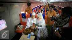 Sepasang mempelai menunjukan buku nikah usai menjalani prosesi nikah massal di kampus STTKD, Yogyakarta, Senin (4/4/2016). Sebanyak 21 pasangan pengantin mengikuti nikah bareng angkasa di atas pesawat boing. (Liputan6.com/Boy Harjanto)