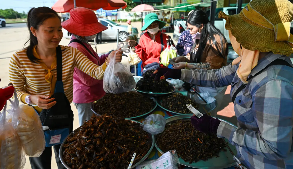 Orang-orang membeli tarantula goreng di kota Skun di provinsi Kampong Cham pada 15 Januari 2023. Wisatawan yang mengunjungi Kamboja sering kali menjadikan tarantula sebagai cemilan yang menantang adrenalin mereka. (Photo by TANG CHHIN SOTHY / AFP)
