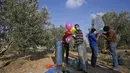 Sejumlah pria Palestina menyiapkan balon dengan alat peledak yang akan diterbangkan ke  Israel disepanjang perbatasan Israel-Jalur Gaza (12/8/2020). Serangan balon api yang dilancarkan menyebabkan terjadinya puluhan kebakaran di areal pertanian Israel. (AFP Photo/Mohammed Abed)