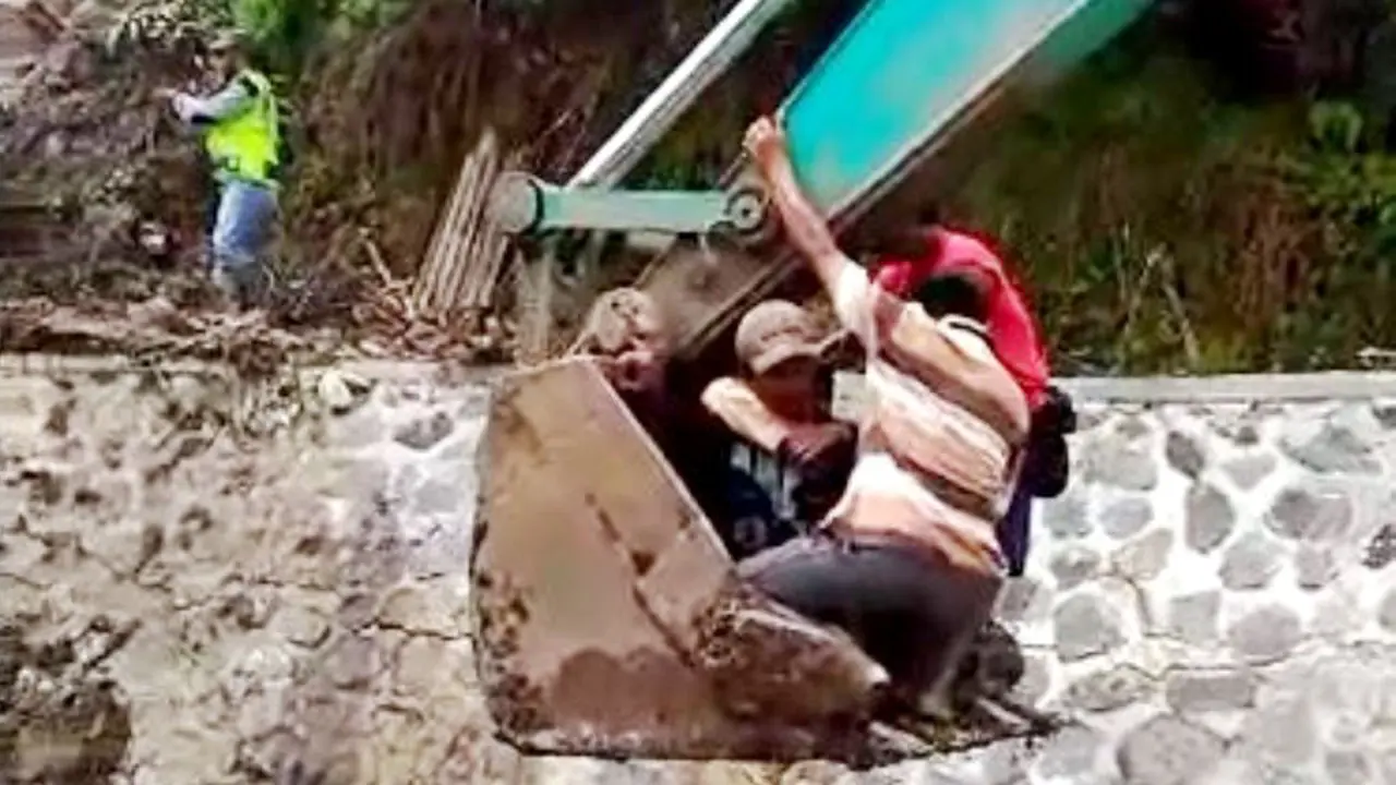 Guru perempuan dinaikkan ke eskavator untuk melewati bidang jalan yang ambles. (Foto: Liputan6.com/RAPI BJN/Muhamad Ridlo)