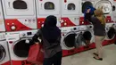 Pekerja memasukkan pakaian ke mesin cuci di gerai jasa layanan laundry, kawasan Kemang, Jakarta, Rabu (25/11/2020). Sejak tiga bulan terakhir omset mereka kembali membaik dan mengalami peningkatan sebesar 20 hingga 30 persen. (Liputan6.com/Herman Zakharia)