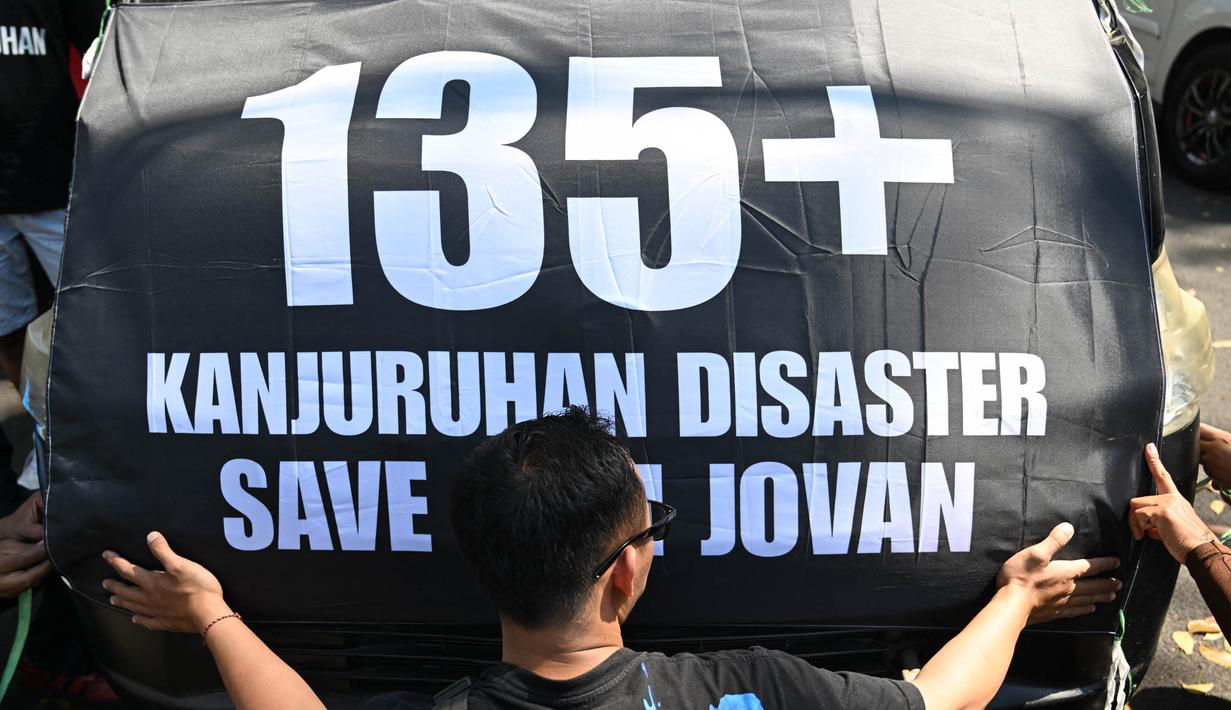 Seorang peserta aksi dalam protes di sepanjang jalan sebelum menghadiri upacara peringatan di Malang, Jawa Timur pada tanggal 1 Oktober 2023. (Juni KRISWANTO/AFP)