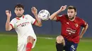 Striker Sevilla, Munir El Haddadi (kiri) berebut bola dengan gelandang Osasuna, Alejandro Pozo dalam laga lanjutan Liga Spanyol 2020/21 pekan ke-24 di El Sadar Stadium, Plampona, Senin (22/2/2021). Sevilla menang 2-0 atas Osasuna. (AFP/Ander Gillenea)