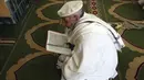 Seorang pria muslim membaca Al-Quran selama melaksanakan salat berjemaah pada hari pertama bulan Ramadan di sebuah masjid di Kabul, Afghanistan, Jumat (24/4/2020). Mereka melaksanakan salat di tengah kekhawatiran akan penularan virus corona COVID-19. (AP Photo/Rahmat Gul)