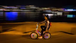 Seorang wanita mengendarai sepedanya dengan hiasan lampu saat berpartisipasi dalam acara Bike the Night di Vancouver, BC, (16/9). Penyelenggara mengharapkan lebih dari 5.000 orang untuk berpartisipasi dalam acara ini. (Darryl Dyck/Canadian Press via AP)
