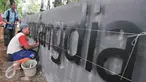 Pekerja memasang plang Ruang Publik Terbuka Ramah Anak (RPTRA) Gondangdia di Jalan Cikini, Jakarta, Senin (19/12). Pemprov DKI Jakarta berencana akan membangun sebanyak 100 RPTRA di tahun 2017. (Liputan6.com/Yoppy Renato)