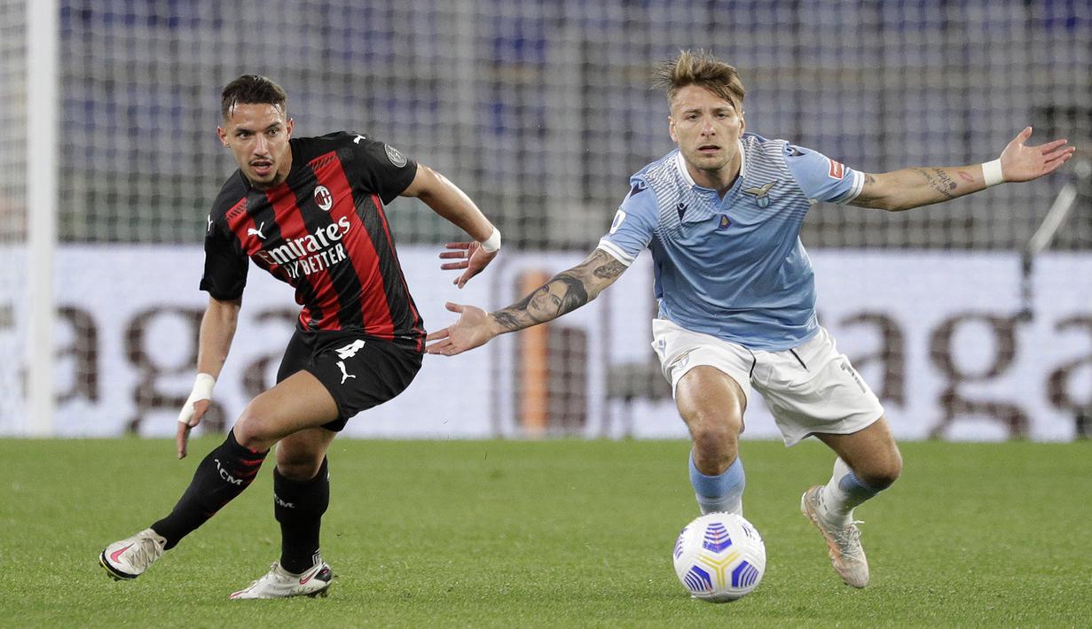 Gelandang AC Milan, Ismael Bennacer (kiri) berebut bola dengan striker Lazio, Ciro Immobile dalam laga lanjutan Liga Italia 2020/2021 pekan ke-33 di Olimpico Stadium, Roma, Senin (26/4/2021). AC Milan kalah 0-3 dari Lazio. (AP/Gregorio Borgia)