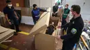 Rodolfo Gomez dan karyawannya mendemonstrasikan desain kardus mereka dapat berfungsi sebagai tempat tidur rumah sakit dan peti mati untuk pasien COVID-19 di Bogota, Kolombia, Jumat (8/5/2020). Perusahaan ini menanggapi kekurangan tempat tidur dan peti mati selama pandemi.  (AP/Fernando Vergara)