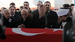 Presiden Turki Recep Tayyip Erdogan menutupi wajah sambil berdoa saat menyalati tentara Turki pertama yang tewas dalam operasi 'Ranting Zaitun' di Suriah, Ankara, Turki, Selasa (23/1). Tentara tewas bernama Sersan Musa Ozalkan. (Foto AP/Burhan Ozbilici)