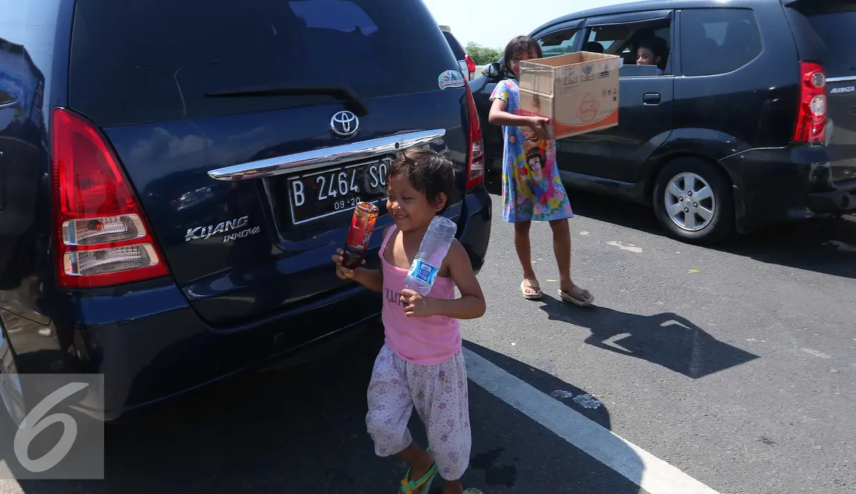 Sejumlah anak berjualan di pintu tol keluar Brebes Timur, Jawa Tengah, (3/7).Hari mudik dan libur sekolah, Sejumlah anak di kawasan tersebut berjalan untuk menjajakan barang dagangannya kepada pemudik yang terkena macet. (Liputan6.com/Angga Yuniar)
