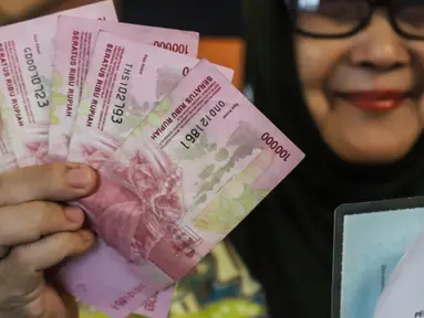 Seorang warga penerima bantuan langsung tunai (BLT) memperlihatkan uang sebesar Rp600 ribu yang baru diterimanya, terkait kenaikan harga BBM di Kantor Pos Pasar Baru, Jakarta, Rabu (7/9/2022). Kementerian Sosial (Kemensos) mulai menyalurkan bantuan langsung tunai (BLT) kenaikan harga BBM kepada 20,65 juta orang melalui PT Pos (Persero) dengan total dana Rp12,4 triliun. (Liputan6.com/Johan Tallo)