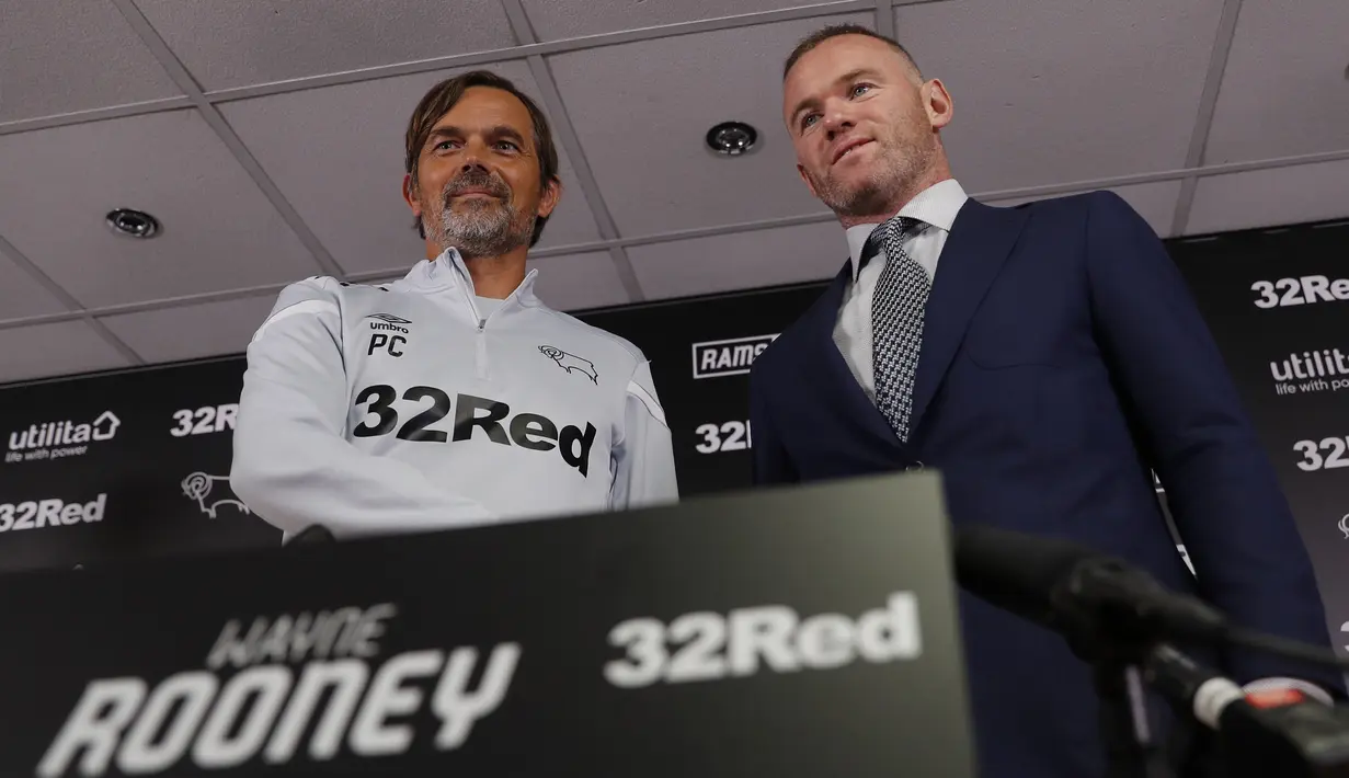 Mantan kapten Inggris, Wayne Rooney dan Manajer Derby County Phillip Cocu berjabat tangan usai konferensi pers di Stadion Pride Park, pinggiran kota Derby, Selasa (6/8/2019). Wayne Rooney diikat kontrak dengan Derby County selama 18 bulan yang akan efektif mulai Januari 2020. (Darren STAPLES / AFP)