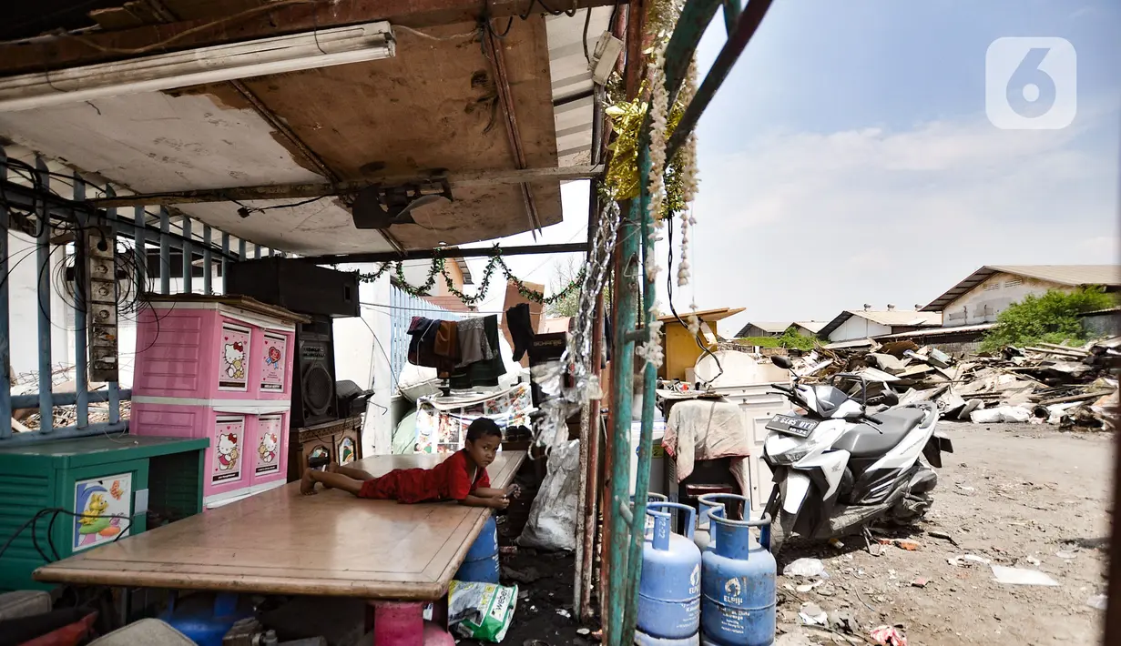Seorang anak berisitrihat di bangunan semipermanen di Jalan Sunter Agung Perkasa VIII, Kecamatan Tanjung Priok, Jakarta Utara, Senin (18/11/2019). Warga akan tetap bertahan hingga pemerintah memberikan uang kompensasi atau merelokasi ke tempat yang lebih layak. (merdeka.com/Iqbal S. Nugroho)