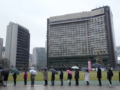 Orang-orang antre untuk menunggu tes virus corona di tempat pengujian darurat di Seoul, Korea Selatan, Jumat (10/12/2021). Otoritas kesehatan Korea Selatan melaporkan lebih dari 7.000 kasus COVID-19 baru untuk ketiga hari berturut-turut pada hari Jumat ini. (AP Photo/Ahn Young-joon)