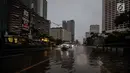 Sebuah mobil melintasi genangan air di kawasan MH Thamrin, Jakarta, Senin (11/12). Hujan lebat yang mengguyur kota Jakarta sejak siang telah mengakibatkan timbulnya genangan air di sejumlah titik di berbagai kawasan. (Liputan6.com/Faizal Fanani)