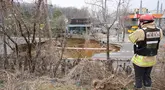 Seorang penyelidik mengambil foto lubang runtuhan di luar sebuah toko tanaman di sebuah jalan di Seoul, Korea Selatan pada tanggal 25 Maret 2025. (Anthony WALLACE/AFP)