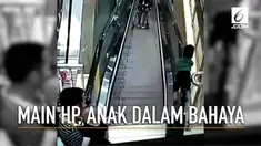 Akibat ayah asyik main ponsel, seorang anak menaiki eskalator dan hampir terjatuh.