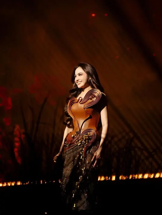 Mahalini Raharja membuka konser tunggalnya dengan kostum bernuansa cokelat dari Wiki Wu. Dress tanpa lengan dengan korset kulit 3D berbentuk hati yang dipadu dengan bawahan drappery emas hitam [@mahaliniraharja]