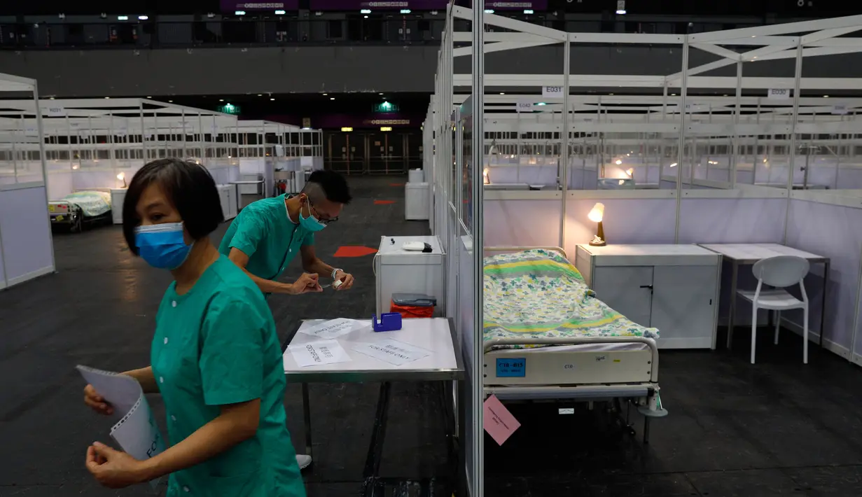 Pekerja medis membuat persiapan di rumah sakit lapangan sementara yang didirikan di Asia World Expo di Hong Kong, Sabtu (1/8/2020). Rumah sakit baru itu akan menerima pasien COVID-19 berusia antara 18 dan 60 tahun dengan sekitar 500 tempat tidur tersedia pada tahap pertama. (AP Photo/Kin Cheung)