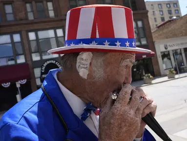 Duane Schwingel, berpakaian seperti Paman Sam memainkan harmonika di luar Fiserv Forum pada hari ketiga Konvensi Nasional Partai Republik 2024 di Milwaukee, Wisconsin, pada tanggal 17 Juli 2024. (Nick Oxford/AFP)