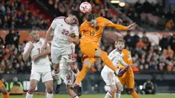 Pemain Timnas Belanda, Wout Weghorst (kanan) berebut bola dengan pemain Timnas Gibraltar, Graeme Troilla pada laga Grup B Kualifikasi Euro 2024 di Feyenoord Stadium, Rotterdam, Belanda, Selasa (28/03/2023) WIB. De Oranje menang dengan skor 3-0. (AP Photo/Peter Dejong)