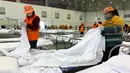 Para pekerja mengatur tempat tidur di pusat konvensi yang diubah menjadi rumah sakit sementara virus corona, Wuhan, Provinsi Hubei, China, Selasa (4/2/2020). Dari 427 korban tewas akibat virus corona, hampir seluruhnya terjadi di China. (Chinatopix via AP)