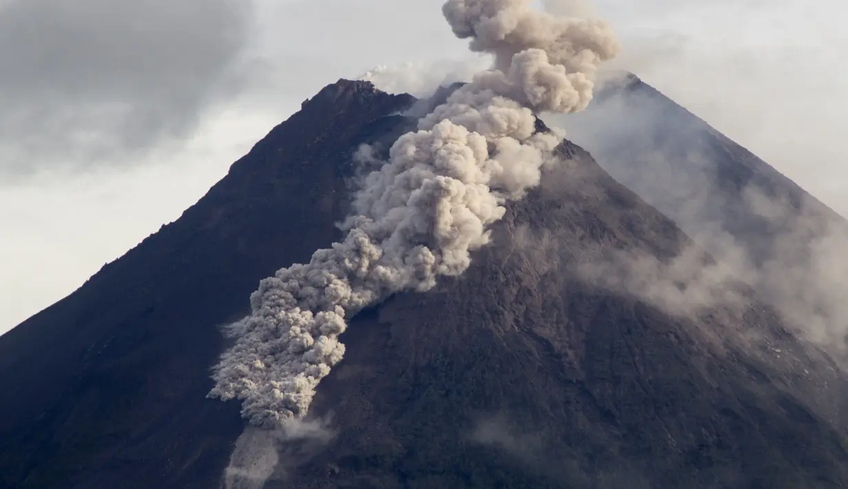 <p>Awan panas dari bahan vulkanik mengalir menuruni lereng Gunung Merapi saat terjadi letusan di Sleman, Yogyakarta (27/1/2021). Gunung berapi paling aktif di Indonesia meletus pada Rabu dengan sungai lava dan awan gas yang membakar mengalir 1.500 meter (4.900 kaki) ke bawahnya. lereng. (AP Photo/Slam</p>