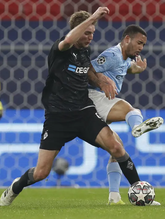 Striker Manchester City, Gabriel Jesus berebut bola dengan gelandang Borusia Monchengladbach Christoph Kramer pada leg pertama 16 besar Liga Champions di Puskas Arena, Kamis (25/2/2021) dini hari WIB. Manchester City tekuk tuan rumah Borusia Monchengladbach 2-0. (AP Photo/Laszlo Balogh)
