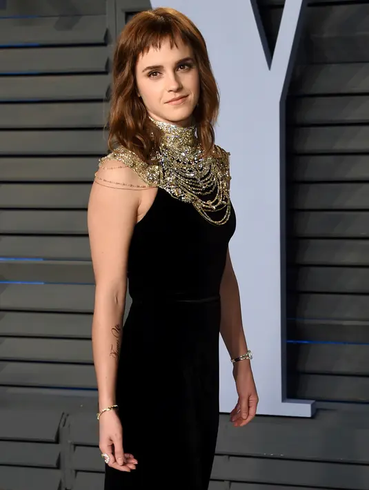 Aktris muda, Emma Watson berpose setibanya pada pesta after-party Vanity Fair Oscar 2018 di Beverly Hills, California, Minggu (4/3). Aksesoris warna emas terlihat melingkar di leher Emma Watson, semakin menambah kesan mewah. (Evan Agostini/Invision/AP)