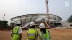 Pekerja melihat progres pembangunan stadion balap sepeda atau velodrom di Rawamangun, Jakarta, Jumat (3/11). Pembangunan velodrom bertaraf internasional ini sudah mencapai 68 persen dan ditarget selesai, Juni 2018. (Liputan6.com/Helmi Fithriansyah)