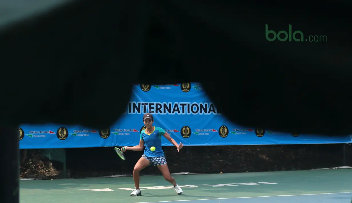 Gaya Petenis Indonesia, Deria Nur Haliza mengembalikan bola ke arah petenis India, Samantha Chamarthi pada kejuaraan ITF Women’s Circuit di Hotel Sulatan, Jakarta, Rabu (18/7/2018). Deria kalah 0-6, 2-6. (Bola.com/Nick Hanoatubun)