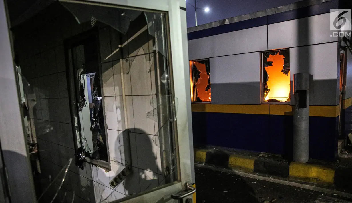 Gardu Tol Pejompongan 1 dibakar massa saat demonstrasi mahasiswa di depan Gedung DPR/MPR, Jakarta, Selasa (24/9/2019). PT Jasa Marga menutup jalan Tol Dalam Kota Cawang-Tomang guna menjaga keselamatan dan keamanan pengguna jalan. (Liputan6.com/Faisal Fanani)