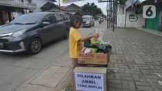 Seorang anak mengambil mi instan dan telur gratis di Jalan Raya Cibubur-Bojong Kulur, Bogor, Kamis (9/4/2020). Di beberapa pinggir jalan Kawasan Jabotabek saat ini banyak aksi solidaritas oleh warga dengan menyediakan bahan makanan gratis di tengah pandemi virus corona. (merdeka.com/Arie Basuki)