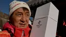 Aktor Jackie Chan terlihat di Tembok Besar Badaling pada hari kedua estafet obor di Beijing pada 3 Februari 2022, sehari sebelum dimulainya Olimpiade Musim Dingin Beijing 2022. (AFP/Noel Celis)