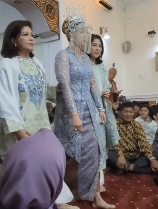 Kebaya panjang tersebut dipadukan kain batik dengan dengan dua warna berbeda. Di bagian depan kain berwarna kebiruan, sementara di bagian batik tersebut berwarna coklat. [@nurasiauno]