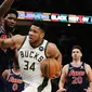 Bintang Milwaukee Bucks Giannis Antetokounmpo berjibaku dengan center Philadelphia 76ers Joel Embiid pada lanjutan NBA 2021/2022 di Fiserv Forum, Kamis (17/2/2022) atau Jumat pagi WIB. (AP Photo/Morry Gash)