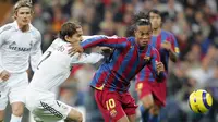 Ronaldinho mengelabui Michel Salgado dalam laga El Clasico di Stadion Santiago Bernabeu, Madrid, (19/11/2005). Ronaldinho mencetak dua dari tiga gol kemenangan Barcelona. (AFP Photo/Javier Soriano)