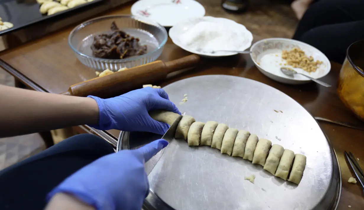 Seorang warga Irak membuat kue tradisional yang dikenal sebagai Kleicha untuk perayaan Idul Fitri di Baghdad, Irak, pada 23 Mei 2020. Kleicha, kue populer yang terbuat dari tepung dan mentega di Irak, dikreasikan dalam berbagai bentuk dengan beragam isian. (Xinhua/Khalil Dawood)