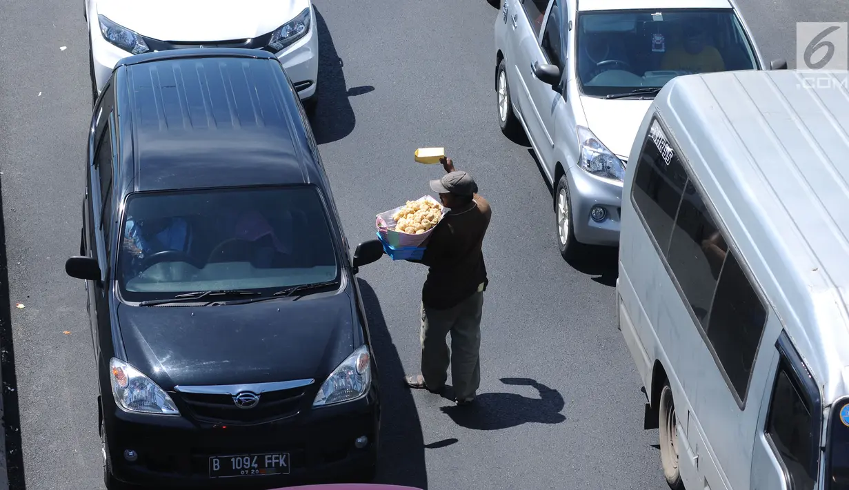Pedagang menjajakan makanan ke pengendara jelang Simpang Tiga Keluar Tol Brebes, Jateng, Sabtu (23/12). Memanfaatkan kepadatan arus libur panjang Natal 2017, pedagang menjajakan dagangan di Simpang Tiga Keluar Tol Brebes. (Liputan6.com/Helmi Fithriansyah)