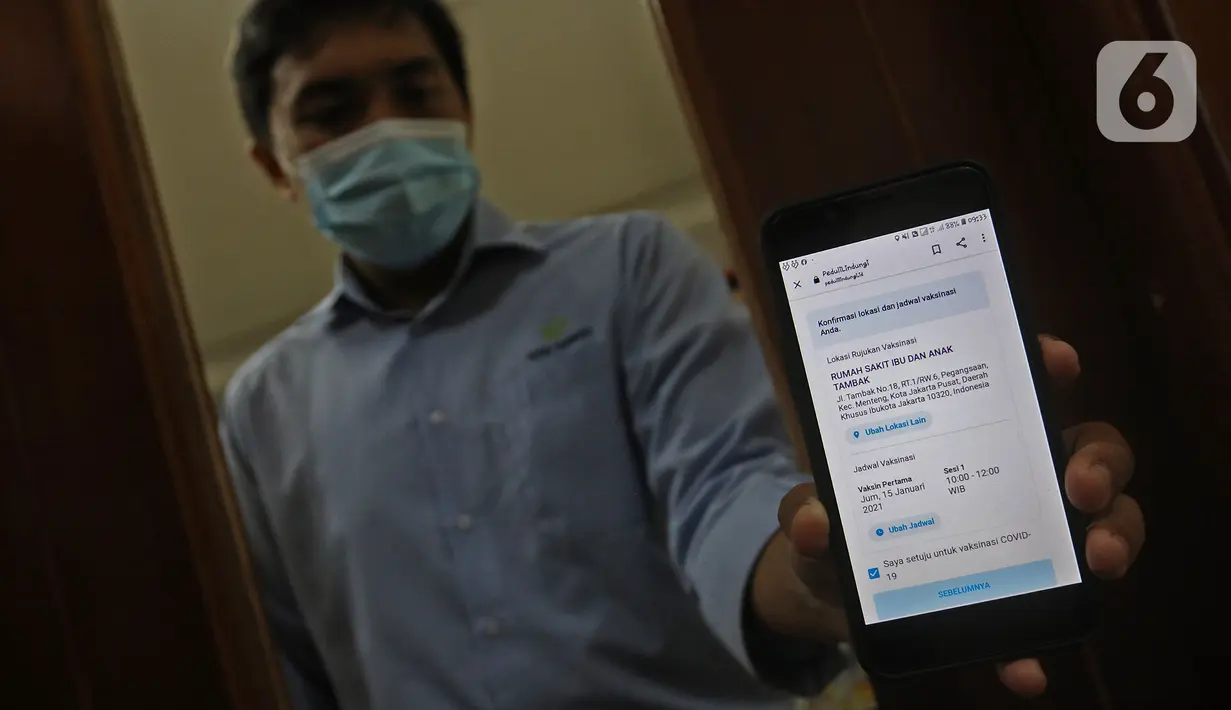 Tenaga kesehatan calon penerima vaksin menunjukkan SMS dalam simulasi pemberian vaksin COVID-19 di RSIA Tambak, Jakarta, Rabu (13/10/2021). Simulasi digelar sebagai persiapan penyuntikan vaksinasi COVID-19 tahap pertama untuk tenaga kesehatan di Jakarta. (Liputan6.com/Herman Zakharia)
