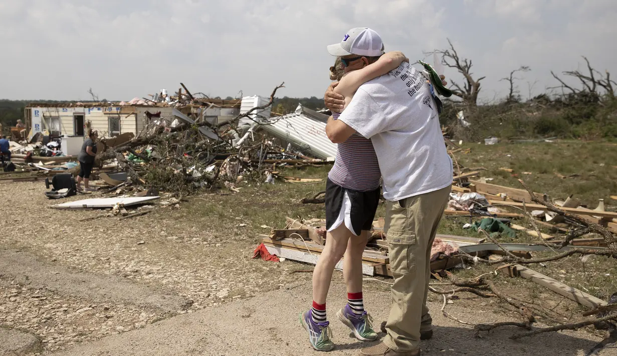 Michelle Light memeluk pamannya Paul Bales sehari setelah tornado menghancurkan rumahnya di FM 2843 dan Cedar Valley Road dekat Salado, Texas (13/4/12). Sekitar puluhan orang terluka akibat tornado yang melanda Texas tengah. (Jay Janner/Austin American-Statesman via AP)