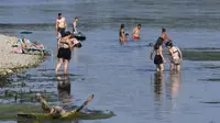 Orang-orang mendinginkan diri di tepi Sungai Ticino, Ponte delle Barche (jembatan perahu), Bereguardo, dekat Milan, Italia, 11 Juli 2023. Gelombang panas yang hebat telah mencapai Italia, membawa suhu mendekati 40 derajat Celcius di banyak kota di seluruh negeri. (AP Photo/Antonio Calanni)