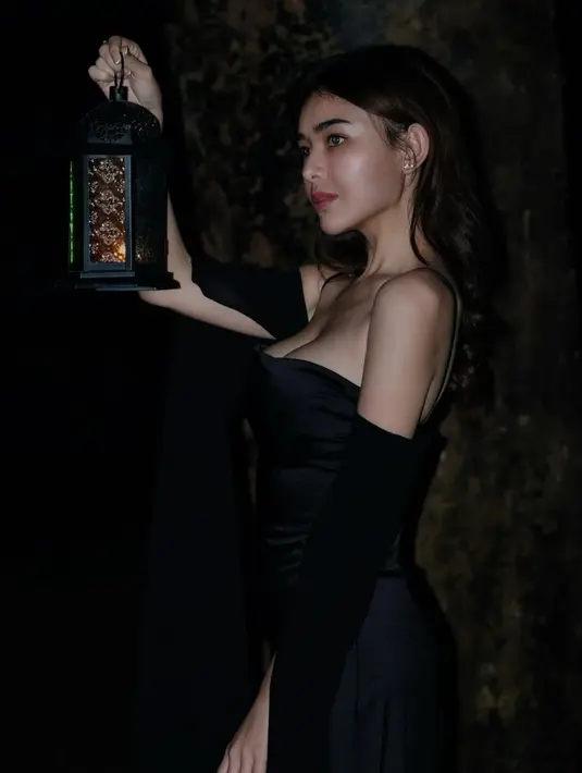 Amanda Manopo tampil misterius dengan spagetti strap dress dan slit gloves. Sambil membawa lentera, Amanda Manopo tetap terlihat misterius meski dengan minim makeup [@amandamanopo]