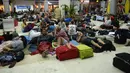 Wisatawan asing tidur di lantai saat menunggu jadwal keberangkatan pesawat di Bandara Internasional Praya Lombok, NTB, Senin (6/8). Imbas gempa 7 SR, para wisatawan terlantar di bandara karena jam pemberangkatan pesawat yang tertunda (AFP/SONNY TUMBELAKA)