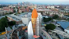 Foto udara menunjukkan pembangunan konstruksi di sekitar pesawat ulang-alik NASA yang ditutupi dengan pembungkus putih pelindung, dan pendorong roket kembar di California Science Center pada tanggal 14 Februari 2024 di Los Angeles, California. (Mario Tama/Getty Images North America/Getty Images via AFP)